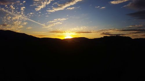 Scenic view of silhouette mountains against sky at sunset