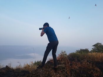 Full length of man standing on landscape against sky