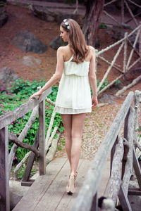 Full length of young woman standing on wood