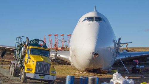 Airplane on airport runway against clear blue sky