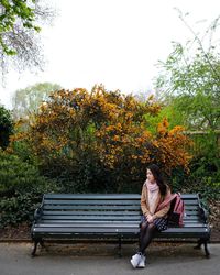 Woman sitting on bench in park