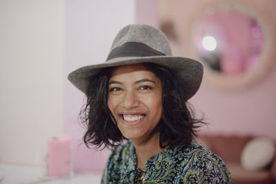 Portrait of young woman wearing hat at home