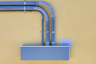 Close-up of yellow wall and electrical conduit