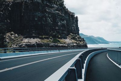 Road leading towards mountains against sky