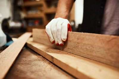 Cropped hands of woman holding wooden table