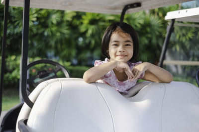 Portrait of smiling girl on golf cart