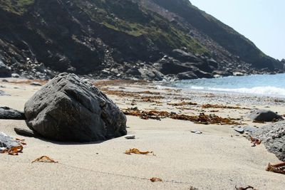 Rocks on beach against sky