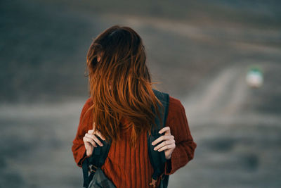 Rear view of woman standing against blurred background