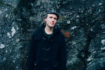 Portrait of young man standing in forest
