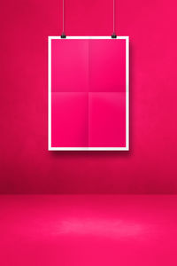 Close-up of empty red hanging on pink wall