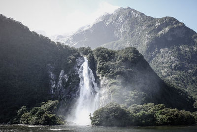 Scenic view of waterfall in forest against clear sky