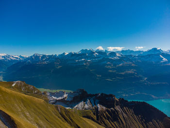 Scenic view of snowcapped mountains against clear blue sky