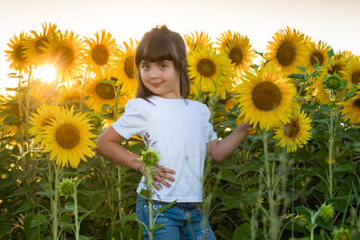 Low angle view of girl standing on sunflower