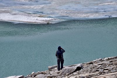 Full length of man standing on rock at beach