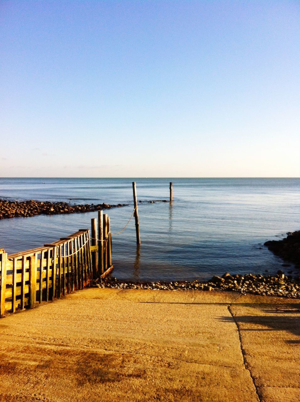 sea, horizon over water, water, clear sky, beach, tranquil scene, tranquility, copy space, scenics, beauty in nature, shore, nature, sand, blue, idyllic, pier, calm, sunlight, outdoors, remote