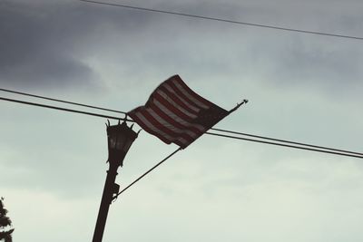 Low angle view of flag against cloudy sky