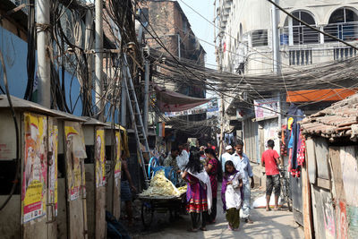 People on street amidst buildings in city