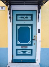 Teal coloured closed door of multicoloured building