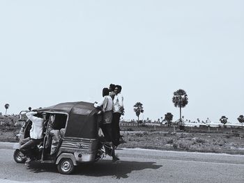 Man cycling on road against clear sky