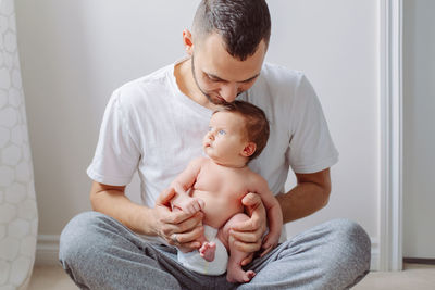 Man holding baby girl at home