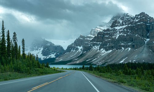 Road amidst snowcapped mountains against sky