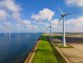 Wind turbines on land against sky