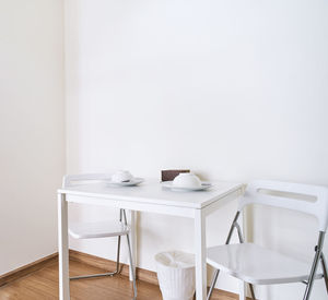 Chairs and table against white wall