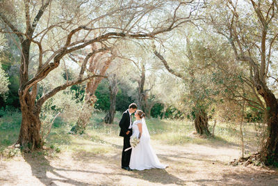 Young couple standing by tree in forest