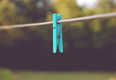 Close-up of clothespins hanging on rope