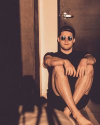 Portrait of young man sitting in sunglasses