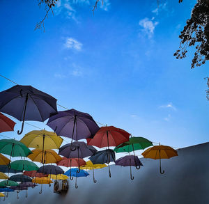 Low angle view of umbrellas hanging against sky