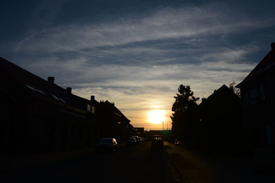 Cars on road against sky during sunset