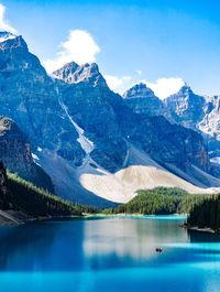 Scenic view of lake and mountains against blue sky