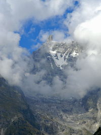 Low angle view of snowcapped mountains against sky