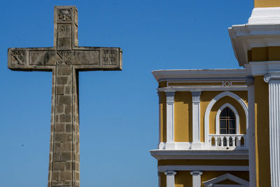 Low angle view of cross against clear blue sky