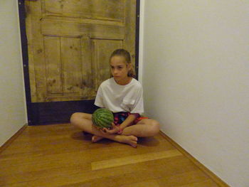 Portrait of young man sitting on floor at home