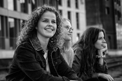 Portrait of smiling young woman sitting outdoors