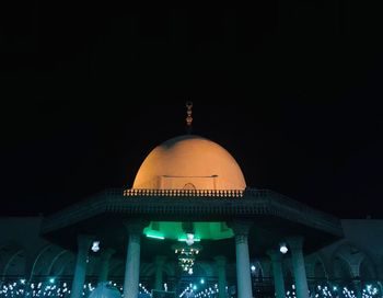 Low angle view of illuminated building against sky at night