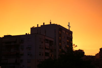 Low angle view of building against orange sky