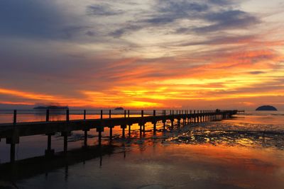 Pier over sea against sky during sunset