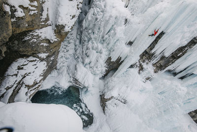 High angle view of man climbing on glacier