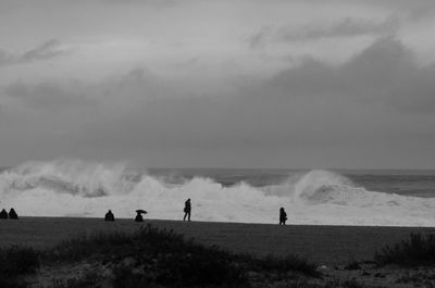 People on beach against sky