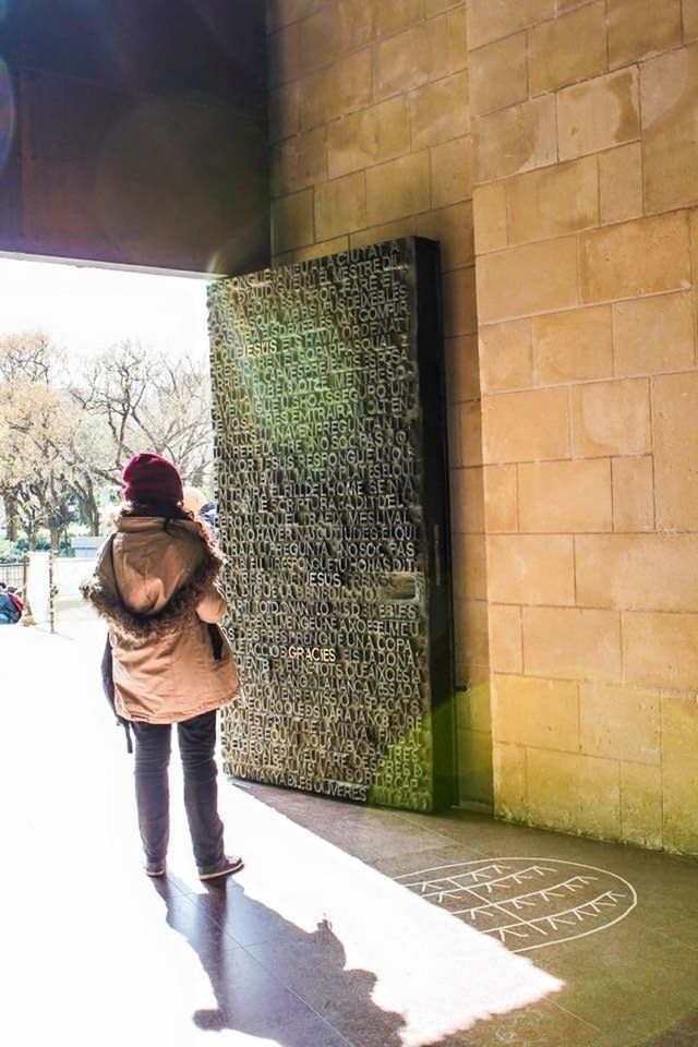 architecture, built structure, building exterior, full length, lifestyles, casual clothing, wall - building feature, standing, leisure activity, rear view, brick wall, walking, stone wall, wall, men, person, day, sunlight