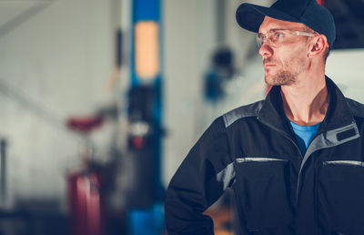 Mechanic looking away at garage