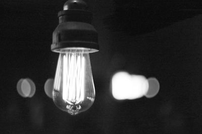 Low angle view of light bulb against black background