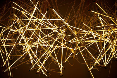 Close-up of illuminated lighting equipment against black background