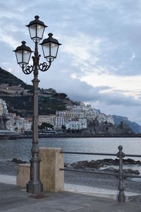 Street light by buildings against sky