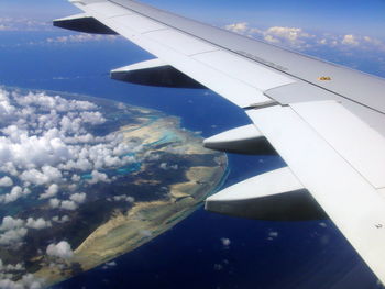 Cropped image of airplane wing over landscape