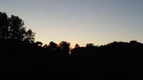 Silhouette of trees against sky at sunset