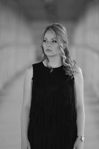 Portrait of beautiful young woman standing against blurred background